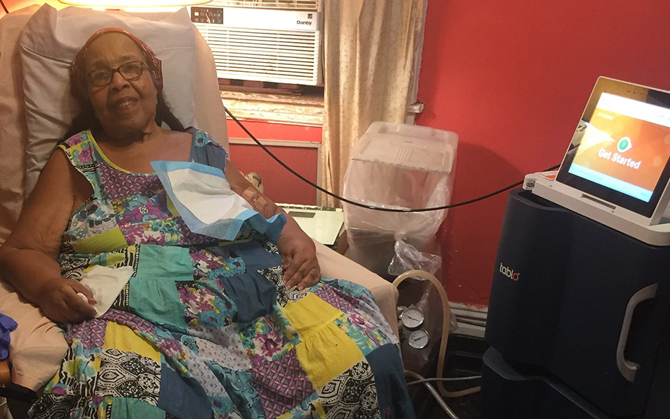 letisha-at-home-in-brooklyn Woman sitting in a chair preparing for treatment on her Tablo Hemodialysis System.
